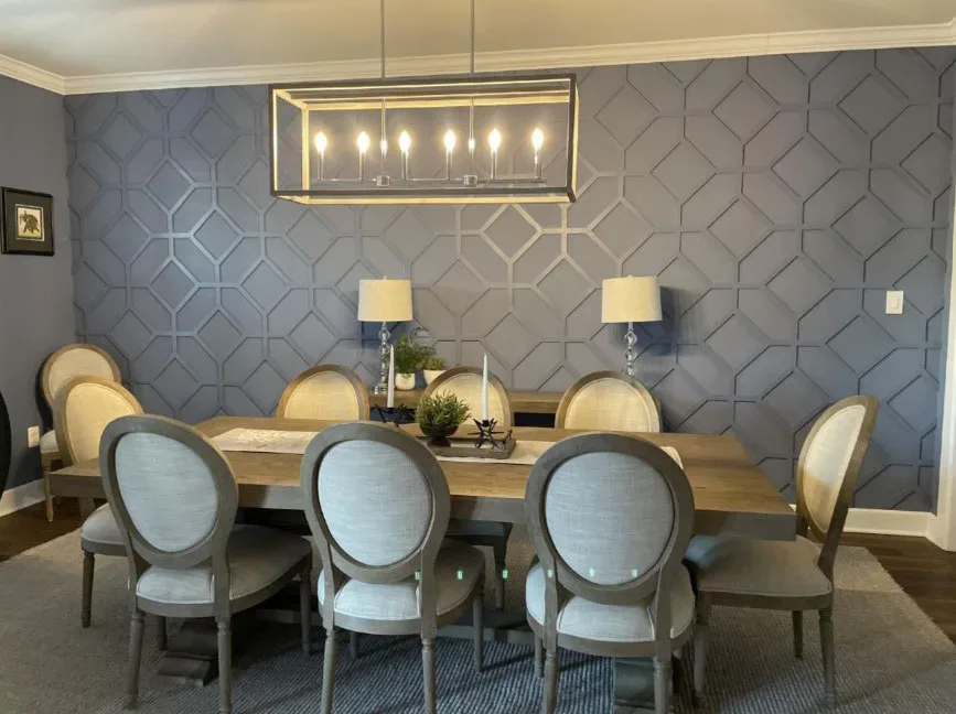 A dining room with gray walls and a chandelier.